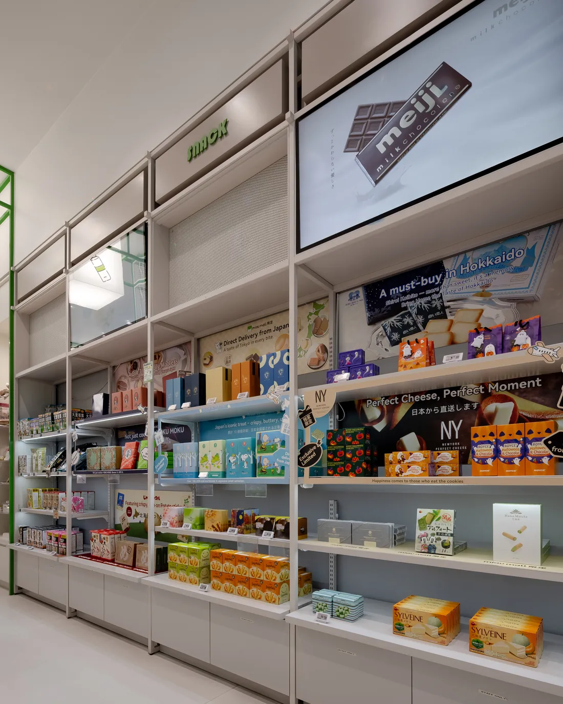 Japanese sweets and snacks on the shelves at MiauMall The Glen, under a Meiji screen